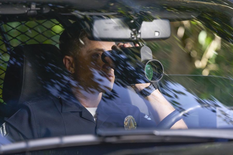 Tim Bradford (Eric Winter) espionne avec ses jumelles les passages qu'ont lieu dans un domaine de criminels.